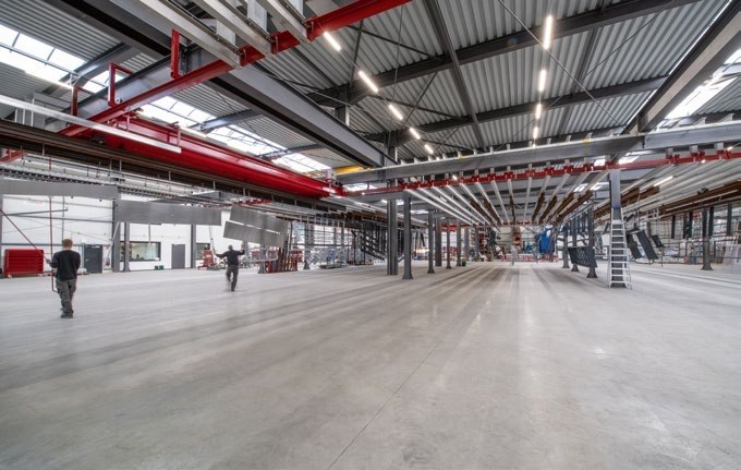 Anlagenhalle bei Huppertz mit roter Deckenfördertechnik und Beschichtungsstationen